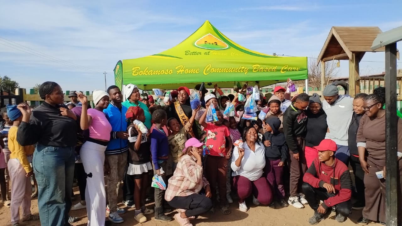 Children and adults celebrating together beneath the Bokamoso canopy